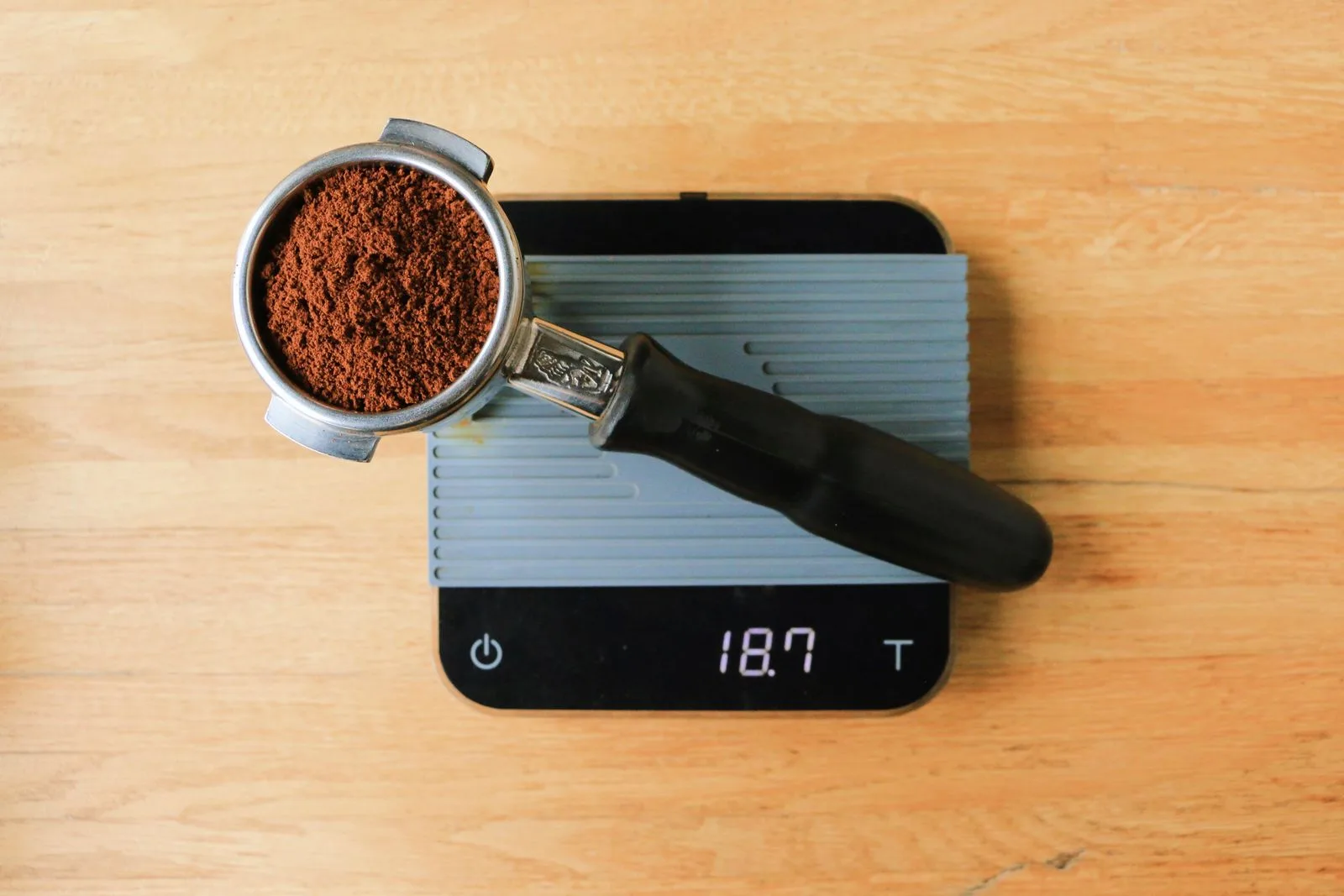 Coffee grounds being weighed on a digital scale during brewing preparation