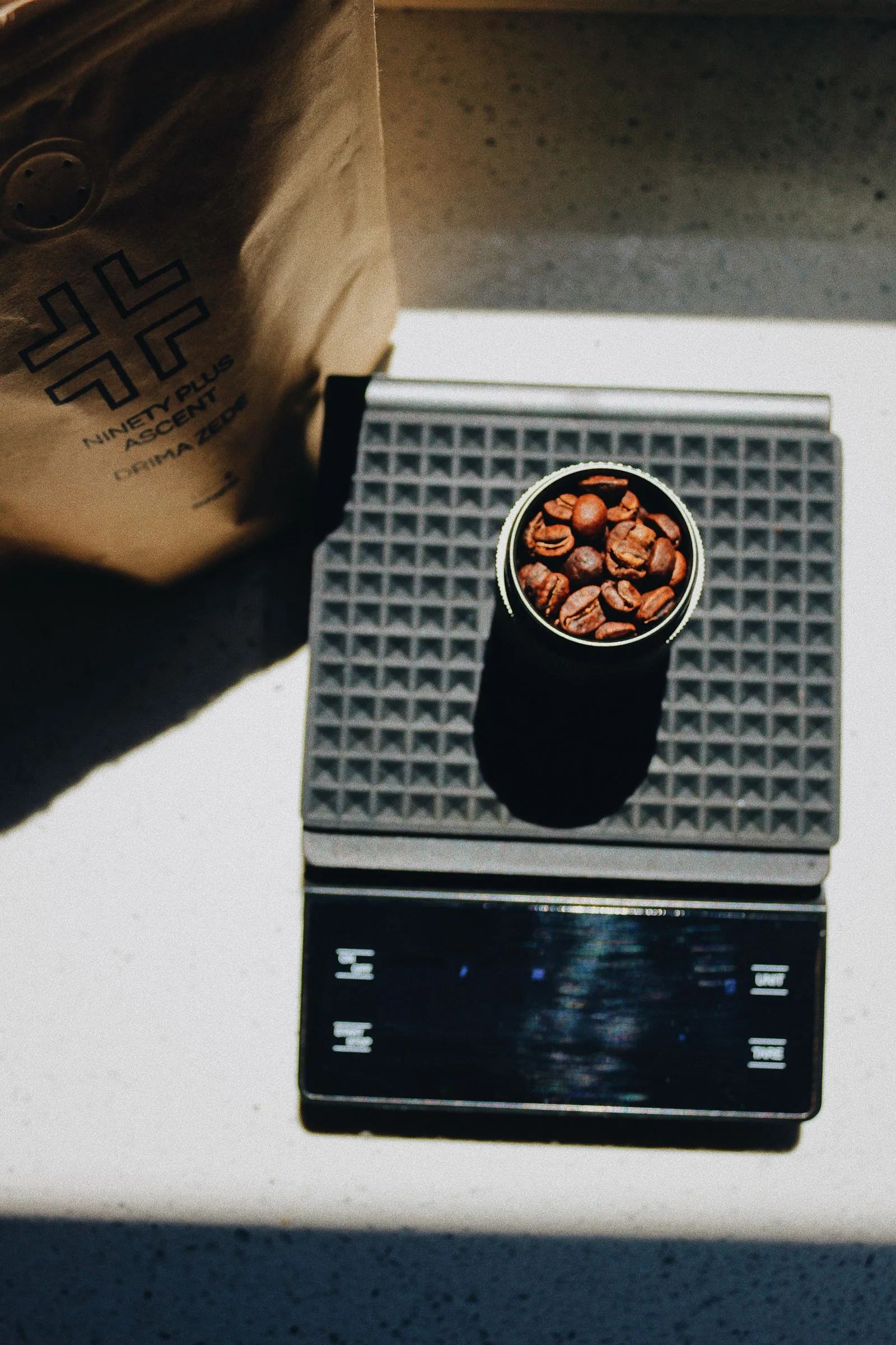Coffee beans in a measuring cup on a digital kitchen scale for precise brewing